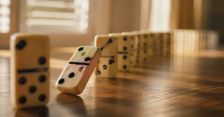 A single domino mid-fall in a long row with soft focus on the rest of the line