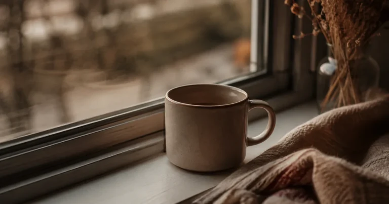 A cup of tea gone cold on a windowsill in fading afternoon light