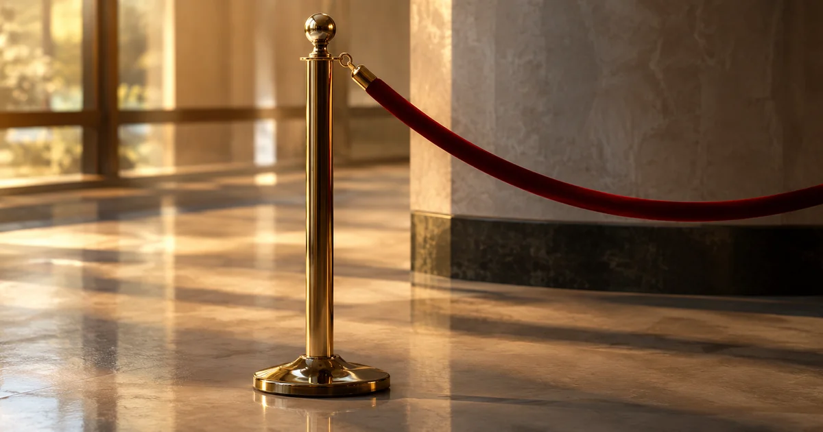 A single velvet rope barrier stanchion standing alone in soft indoor light